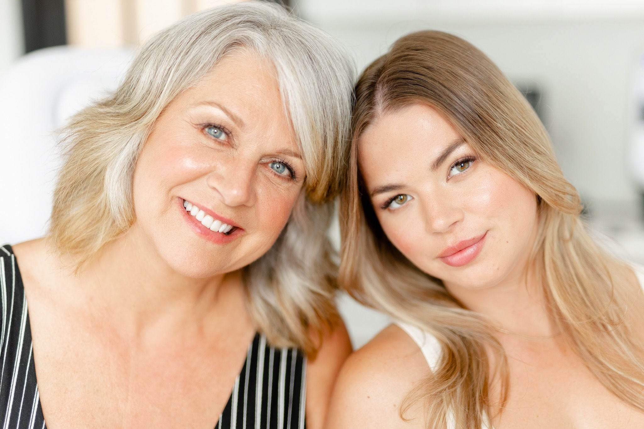 Smiling mature and young woman side by side, representing multi-generational beauty and confidence after aesthetic treatments