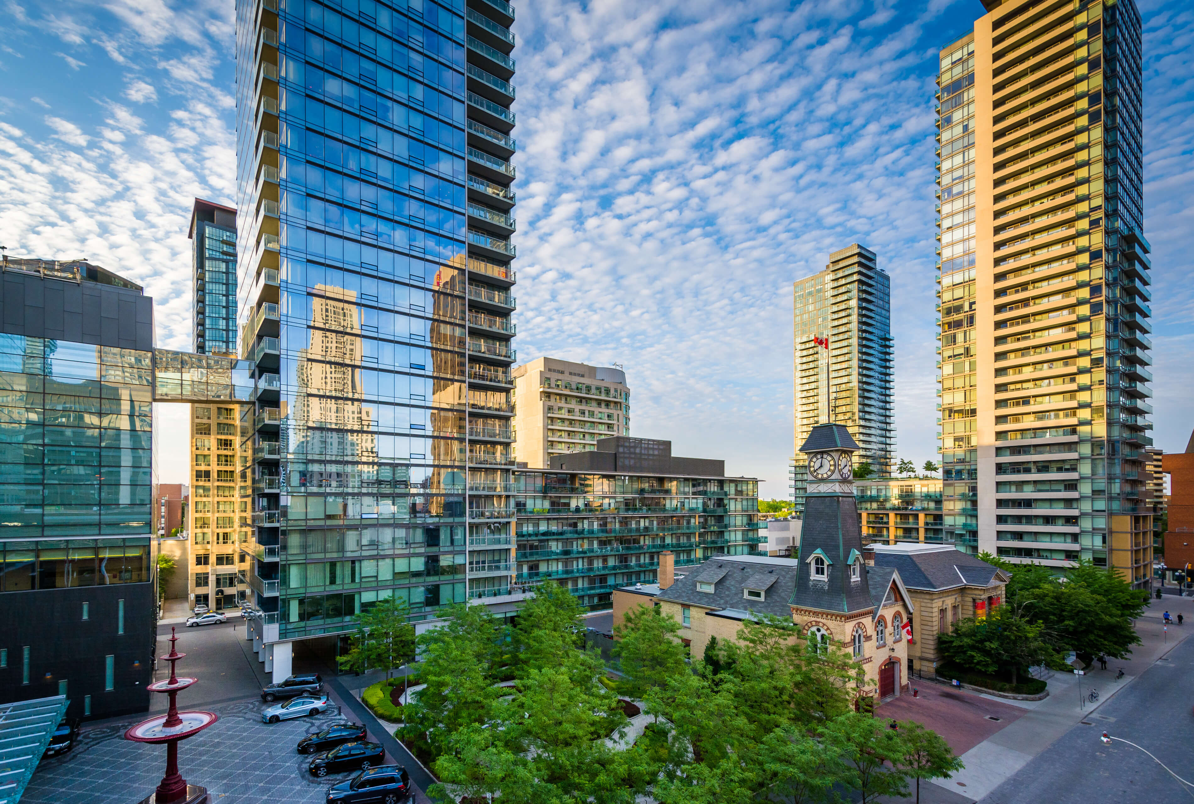 Cityscape with modern high-rise buildings and a church steeple.