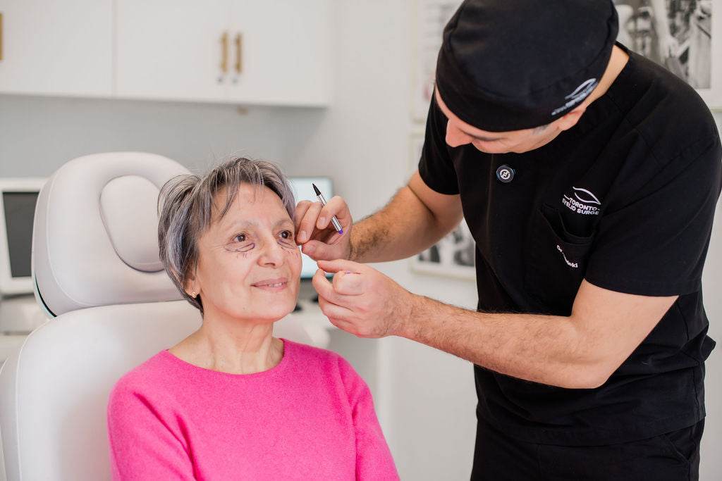 Dr. Babak Maleki performing a facial consultation on a senior female patient in a modern aesthetic clinic
