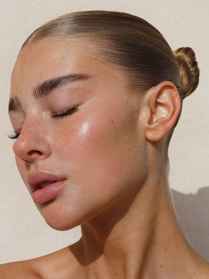 Woman with radiant, youthful face and natural facial volume after fat transfer procedure, showcasing smooth skin and defined contours