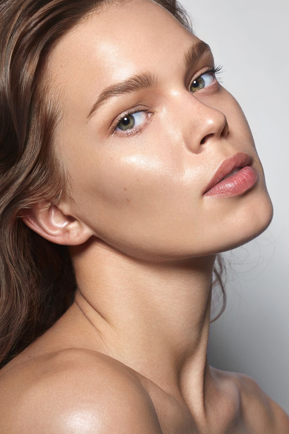 Close-up portrait of a woman with glowing, flawless skin and defined features