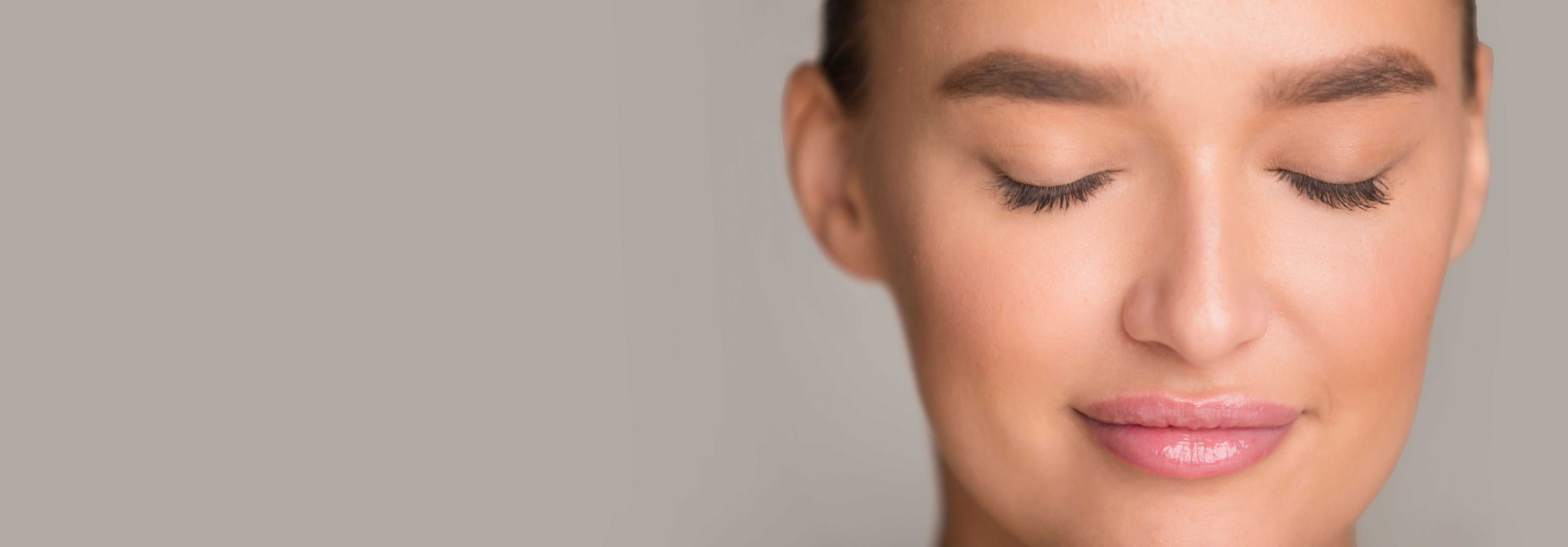 Close-up of a woman’s face with closed eyes and smooth skin, representing results of undereye vein treatment