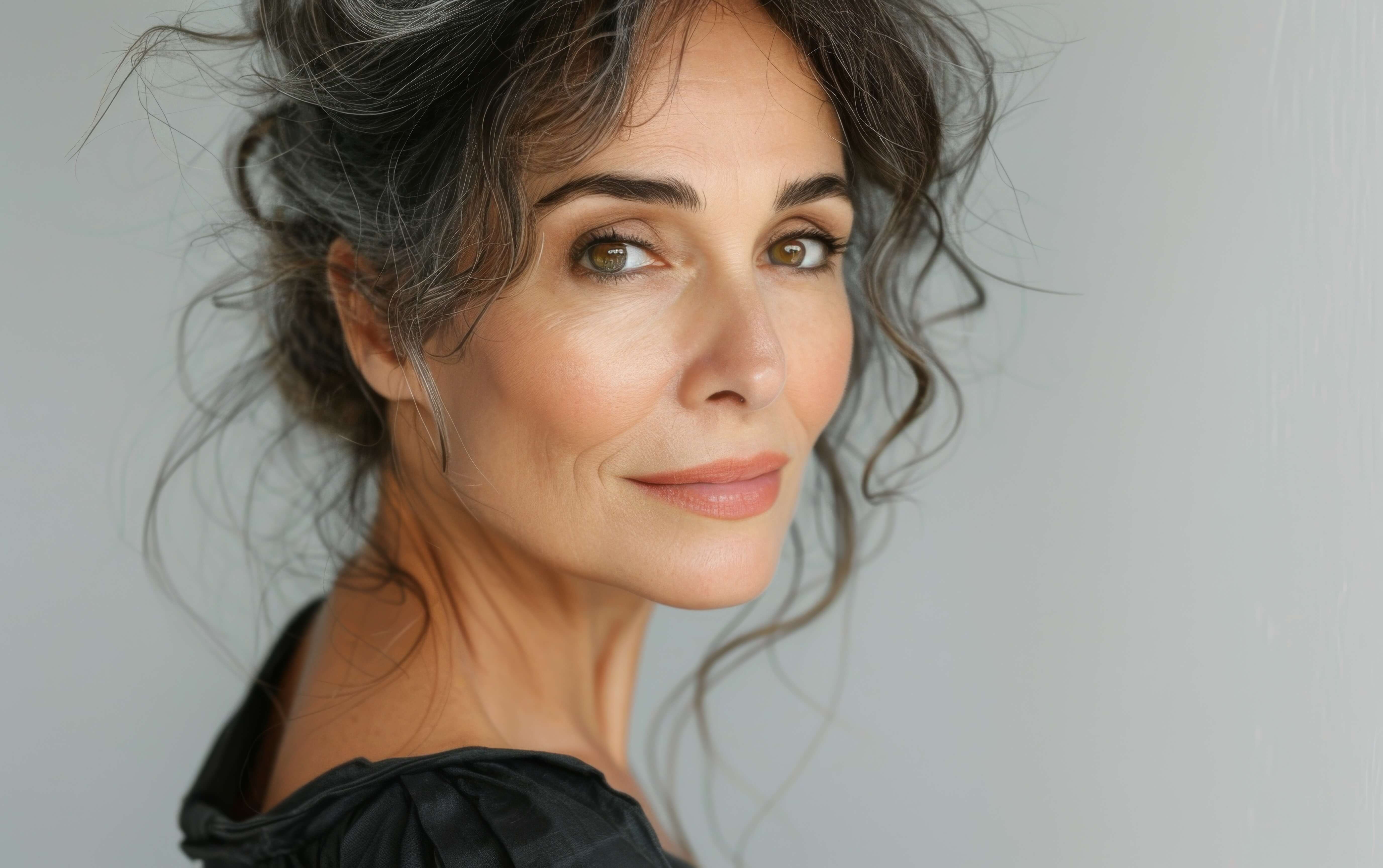 Woman with wavy hair against a plain background